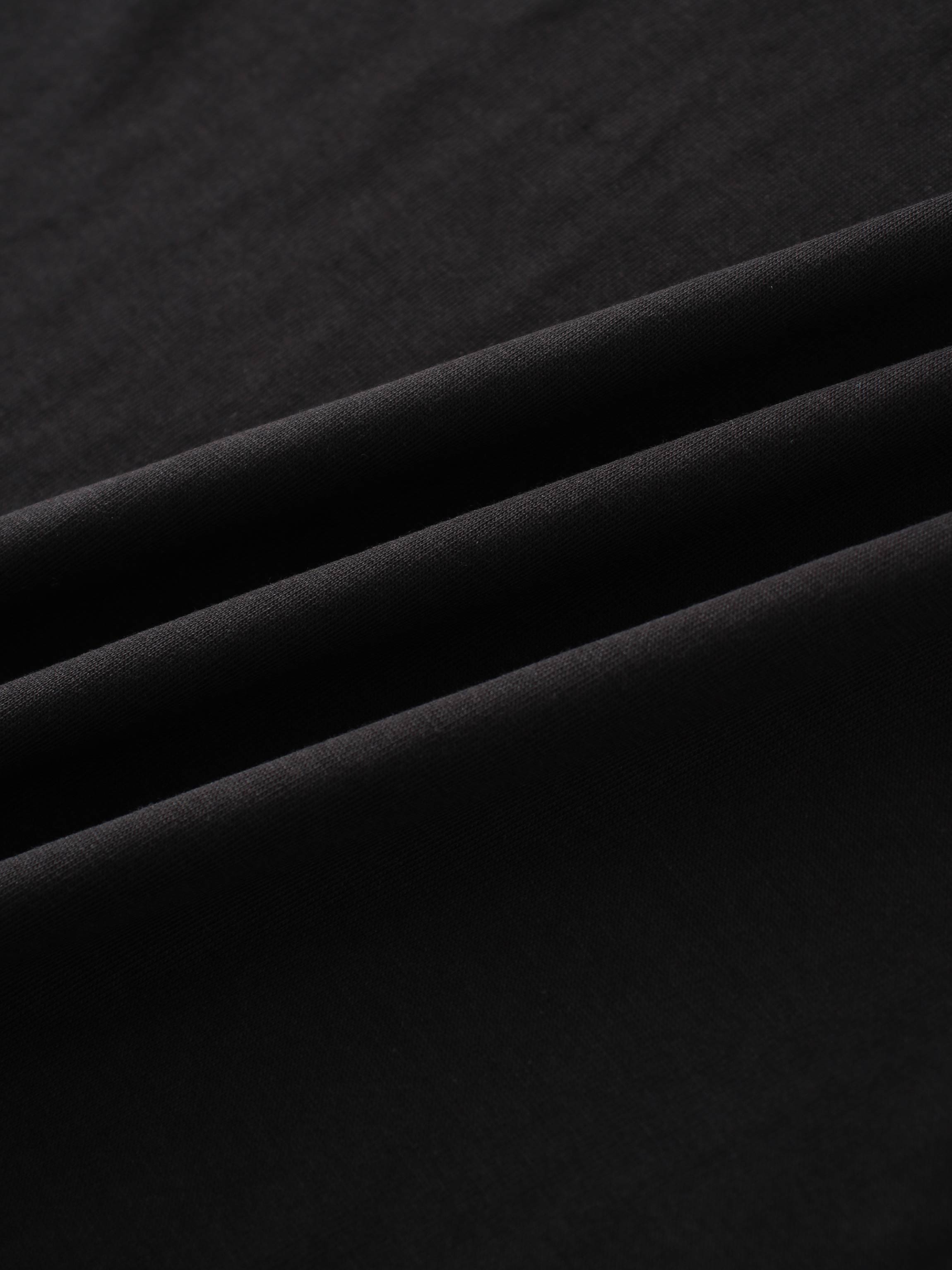 This is a detailed shot of a soft, black textile, showing its gentle folds and smooth, matte finish.