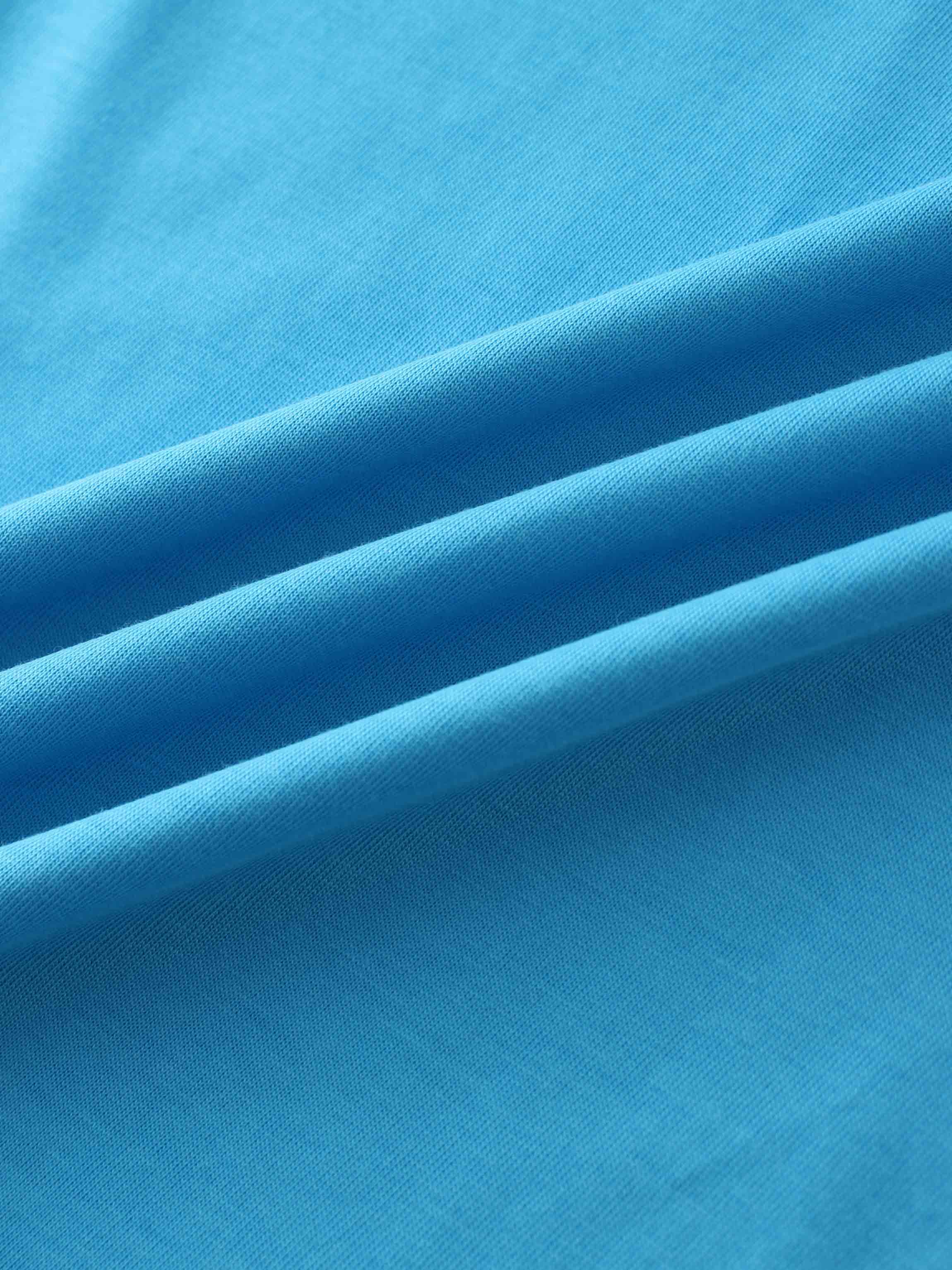 A close-up of a smooth fabric in a vibrant, bright blue color. The material is gathered into soft, diagonal folds.