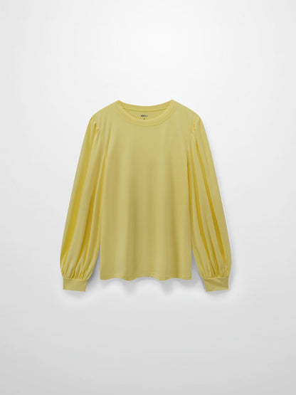 A full, front view of the pale yellow, long-sleeved shirt. It shows the puffed shoulders and voluminous sleeves that gather into fitted cuffs.