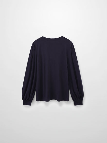 A full, back view of the dark purple, long-sleeved shirt. The puffed shoulders and voluminous, gathered sleeves are visible from behind.