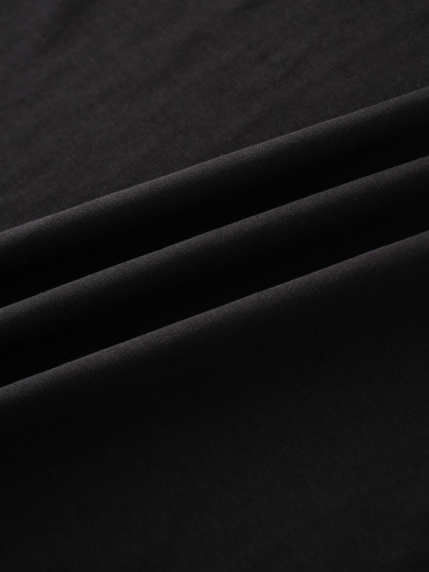 This is a detailed shot of a soft, black textile, showing its gentle folds and smooth, matte finish.