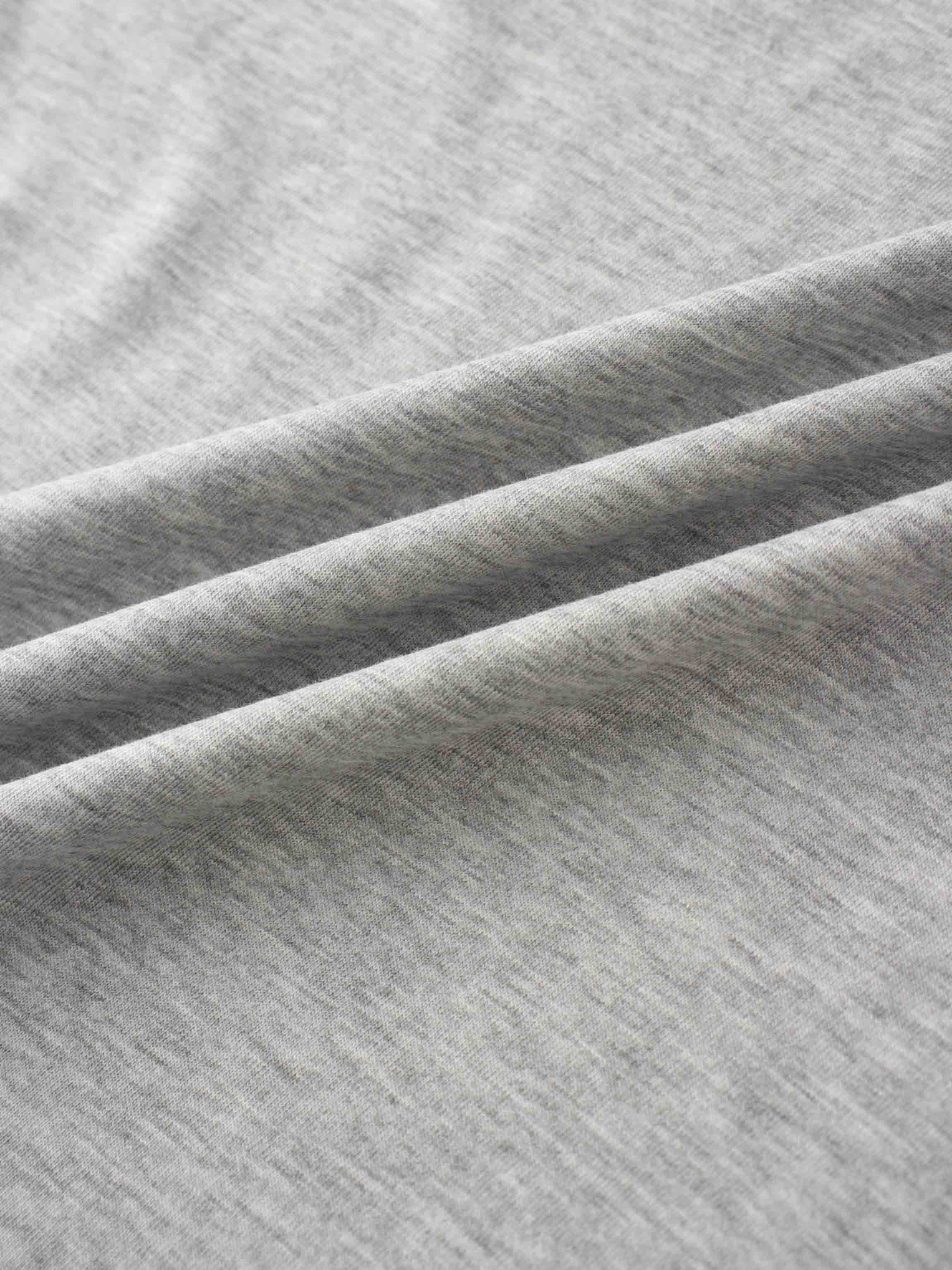 A close-up view of the smooth, heather gray fabric. The material is gathered into several soft, diagonal folds.