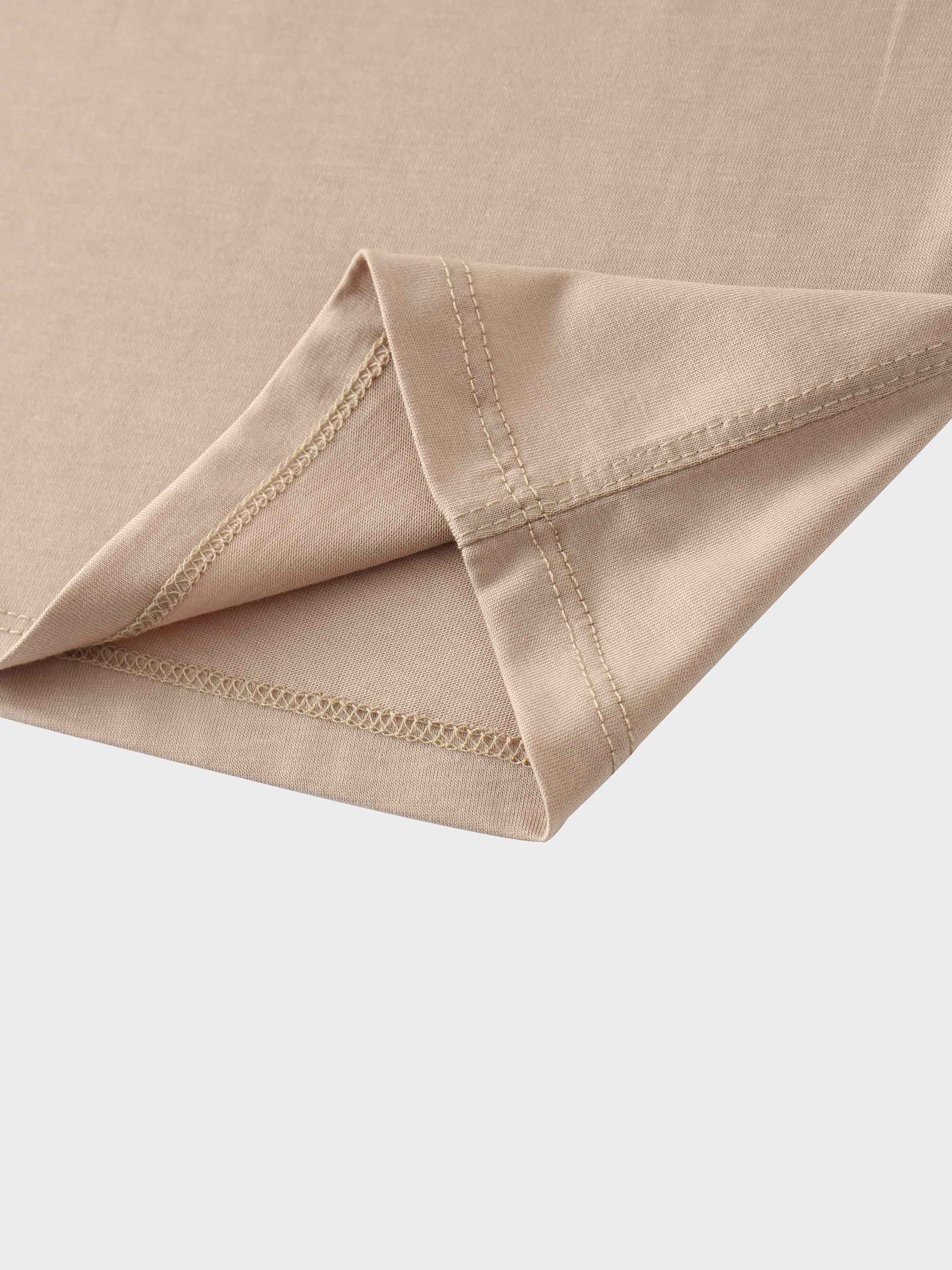 A close-up view of the hem of a sleeve or shirt. The smooth, light-beige fabric is folded and finished with a neat, double-stitched seam.
